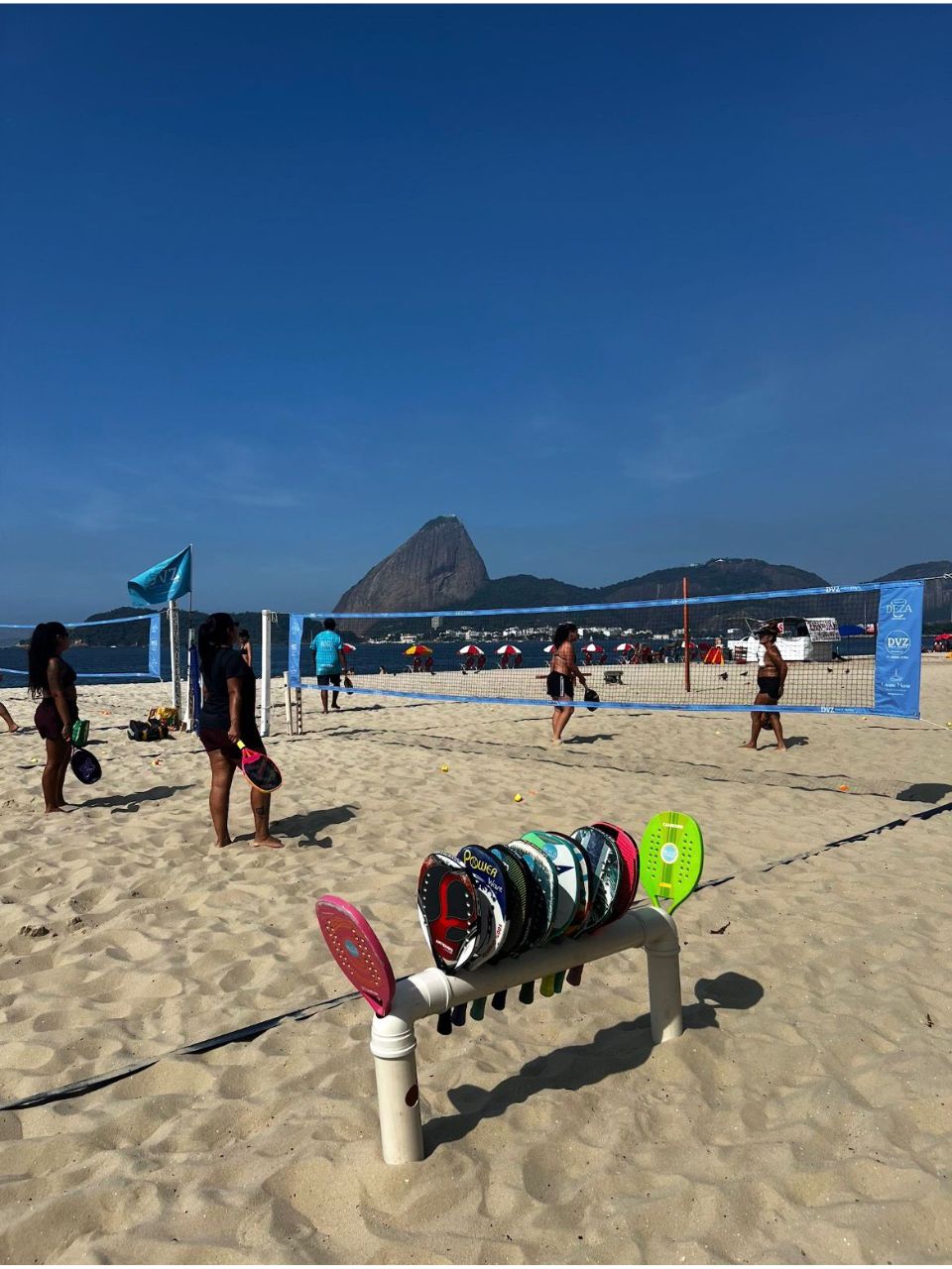Raquetes e cesto cheio de bolinhas de beach tennis